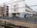 明るい配色の３階建て施設の外観。建物は落ち着いた住宅街の中に佇んでいる。玄関前には緩やかなスロープが設置されている。