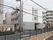 施設の周囲には同じような高さの建物が並んでおり、しっくりと馴染んでいる。道路を挟んで小さな川が流れている。