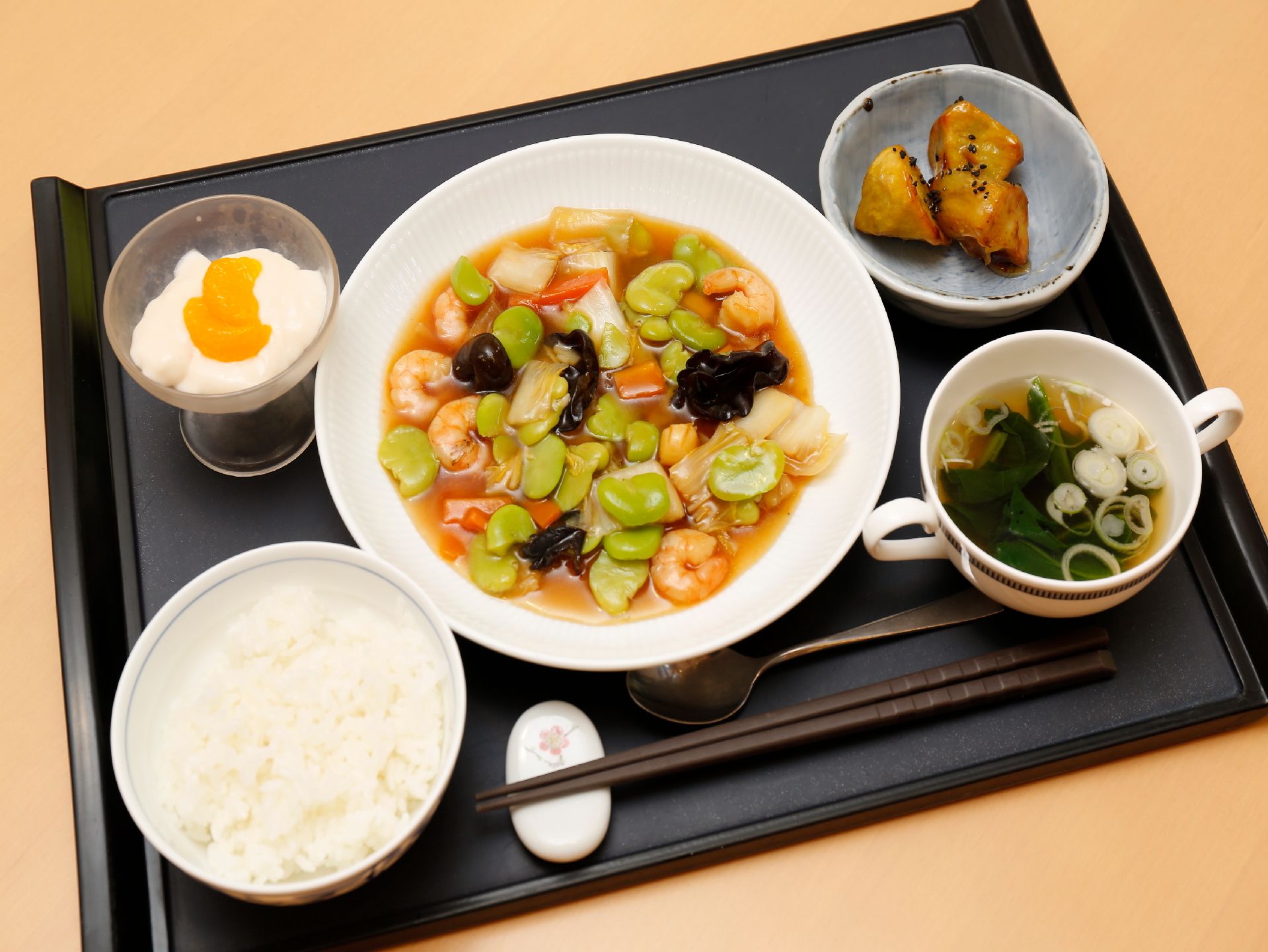 施設で出される食事である。プレートに主食、汁物、主菜、副菜、デザートが乗っている。またおはし以外にはスプーンがついている。