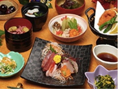 刺身や揚げ物、煮物があり、品数豊富な料理が並ぶ食卓