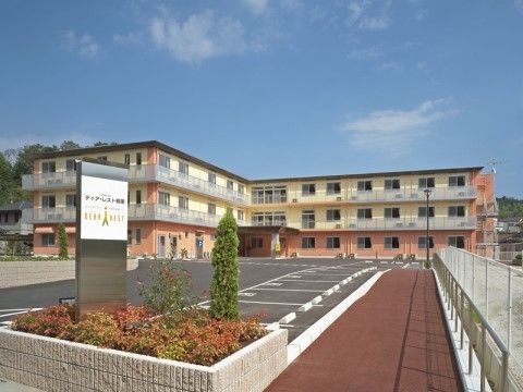 「ケアホーム ディア・レスト岩国」の外観。車の駐車スペースも設けている。
