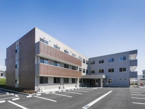 広い駐車場が完備しており、入り口には庇があるベランダ付の建物
