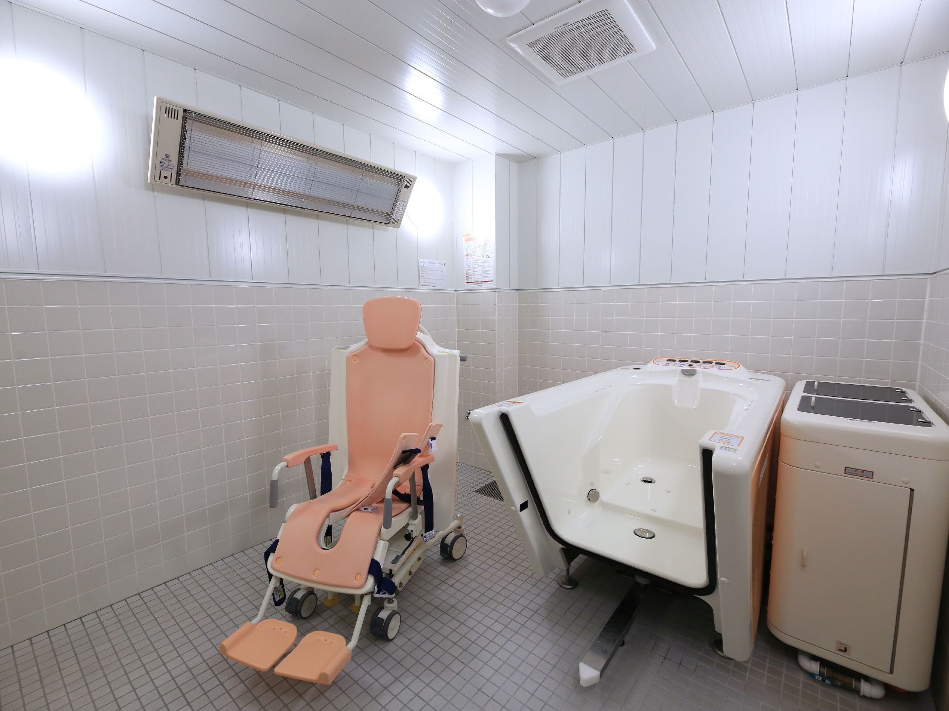 介護浴専用の機械が備わっている。広々としており、清掃が行き届いている。壁に入浴をサポートする照明が取りつけられている。