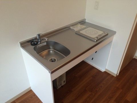 小さなキッチンには、流しとIHコンロが付いている。床はフローリングになっており、車椅子をご利用の方でもスムーズに移動できる。