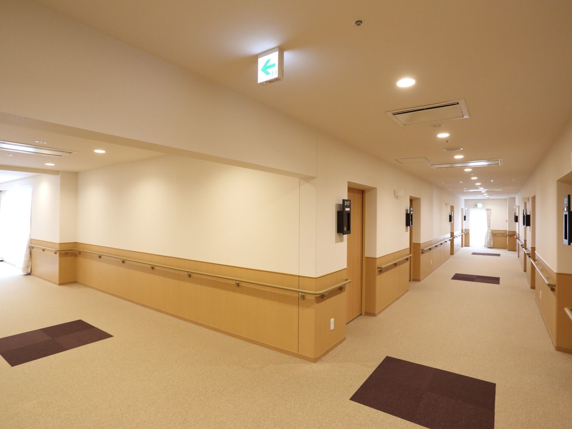 落ち着いた色合いの通路である。また清潔感もあり掃除も行き届いている。窓から入ってくる外の光で通路全体が明るい。