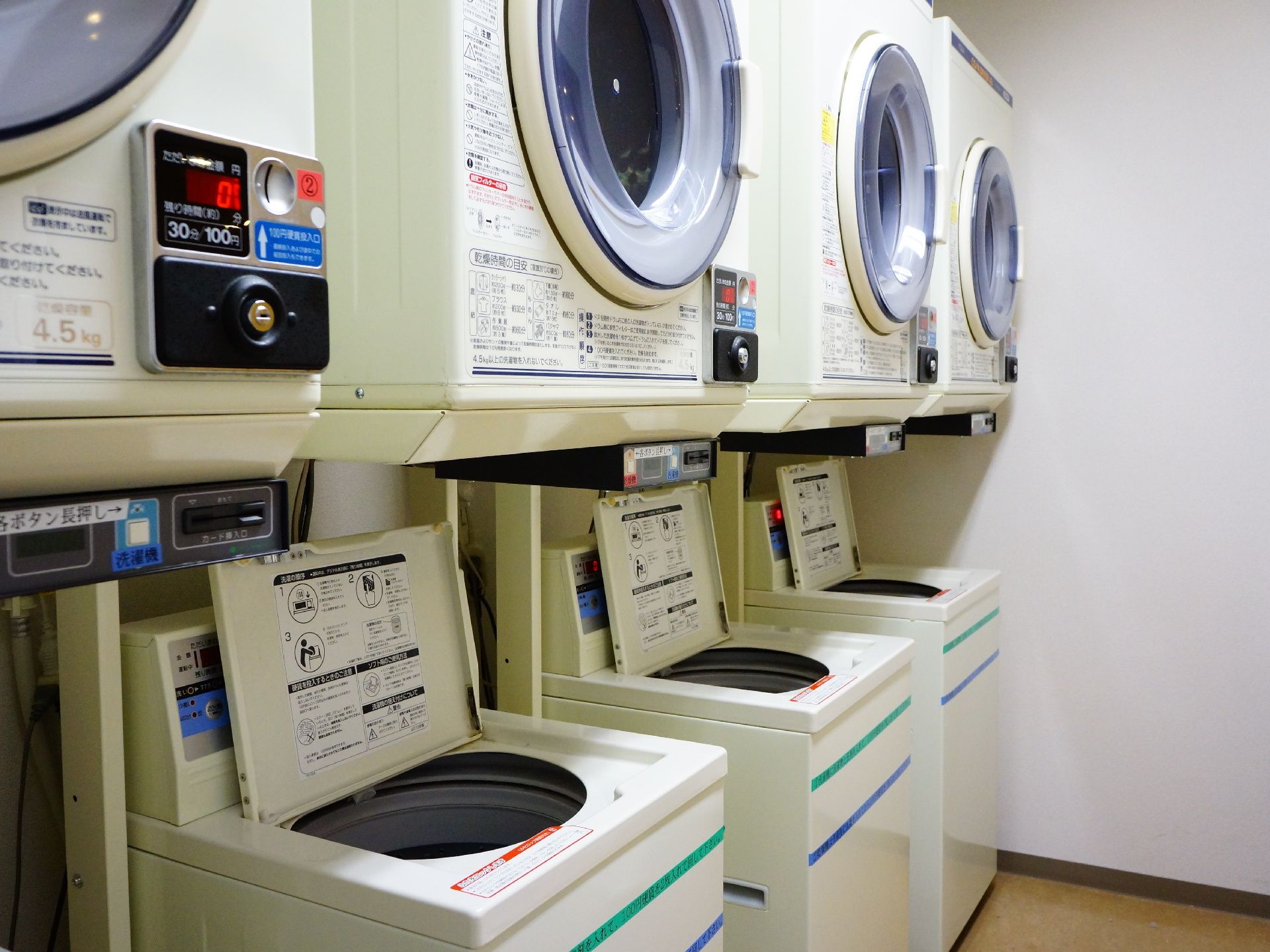 エレベーターの横にあるので移動に便利。乾燥機と全自動洗濯機が4台ずつ設置。町のコインランドリーと同じ。