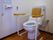 白と茶色を基調としたトイレには、椅子のひじかけのような手すりや、背もたれが設置されている。緊急用のボタンもあるので安心である。