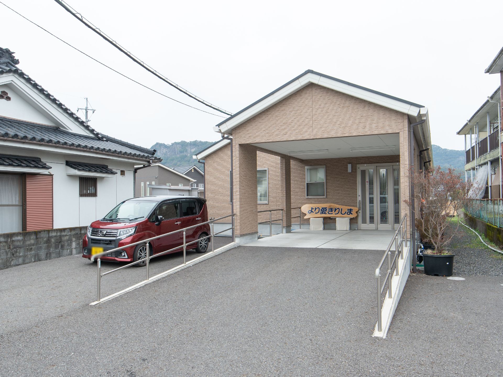 ブラウンを基調とした外観のグループホーム。玄関までのアプローチには段差がなく、スロープが設置されている。