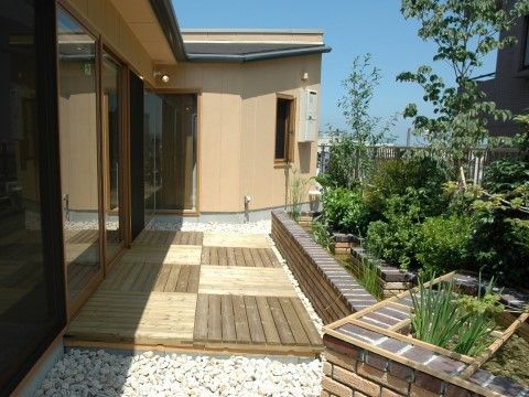 れんが造りの花壇に植えられた緑を眺めながら、ゆっくりと過ごすことができる屋上庭園。ウッドデッキもあるので、掃き出し窓から出入りできる。