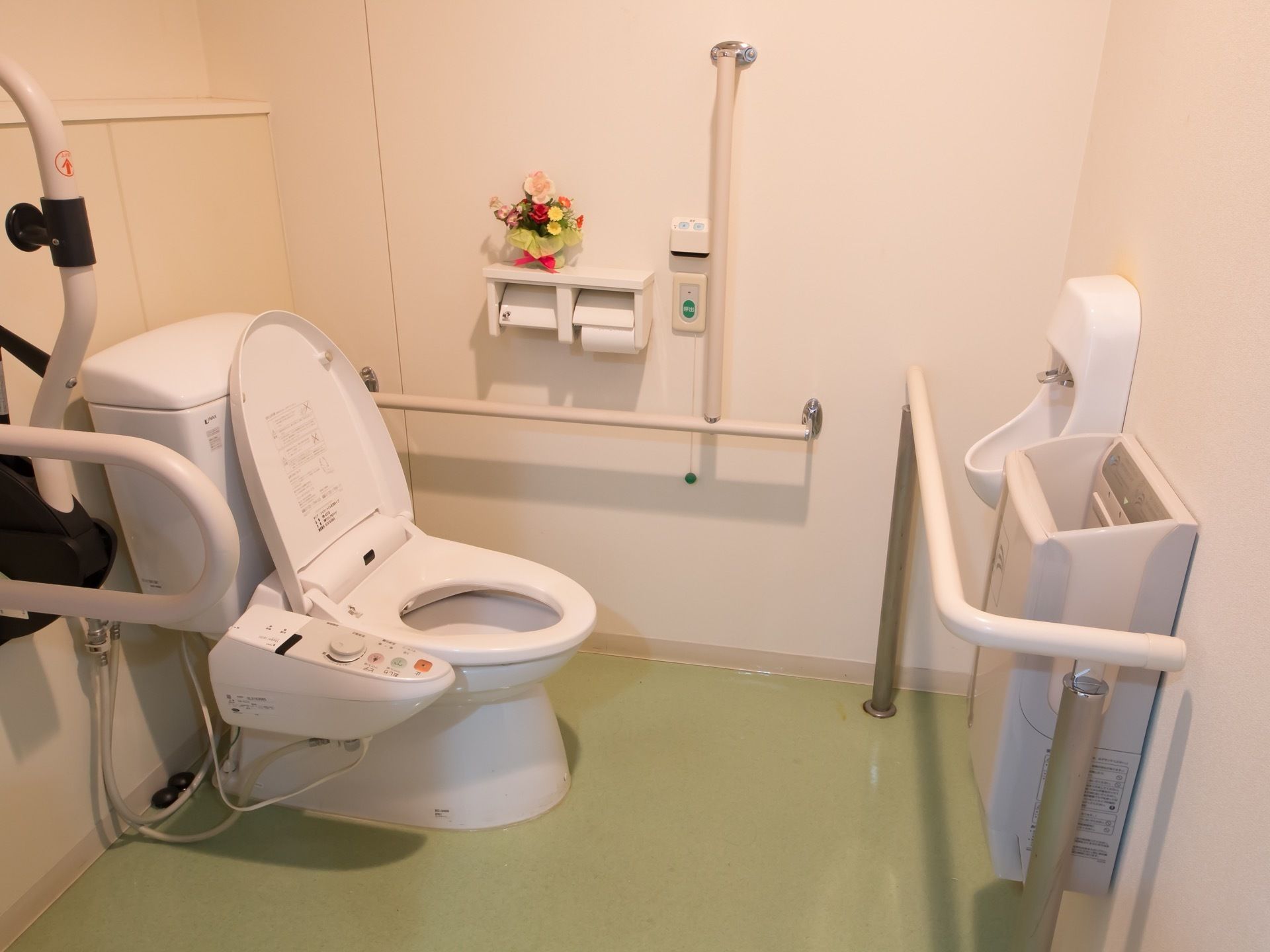 温水洗浄機付きのトイレがあり、周囲の壁に手すりが取りつけられている。手洗い場や手の乾燥機も設置されている。