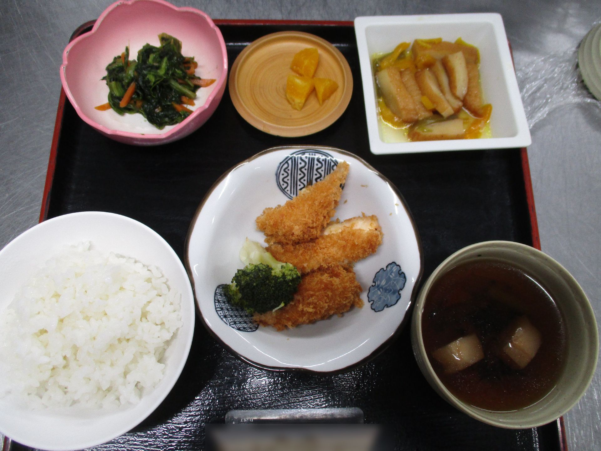 メインが揚げ物で、ご飯や汁物、副菜がお盆に載っている食事