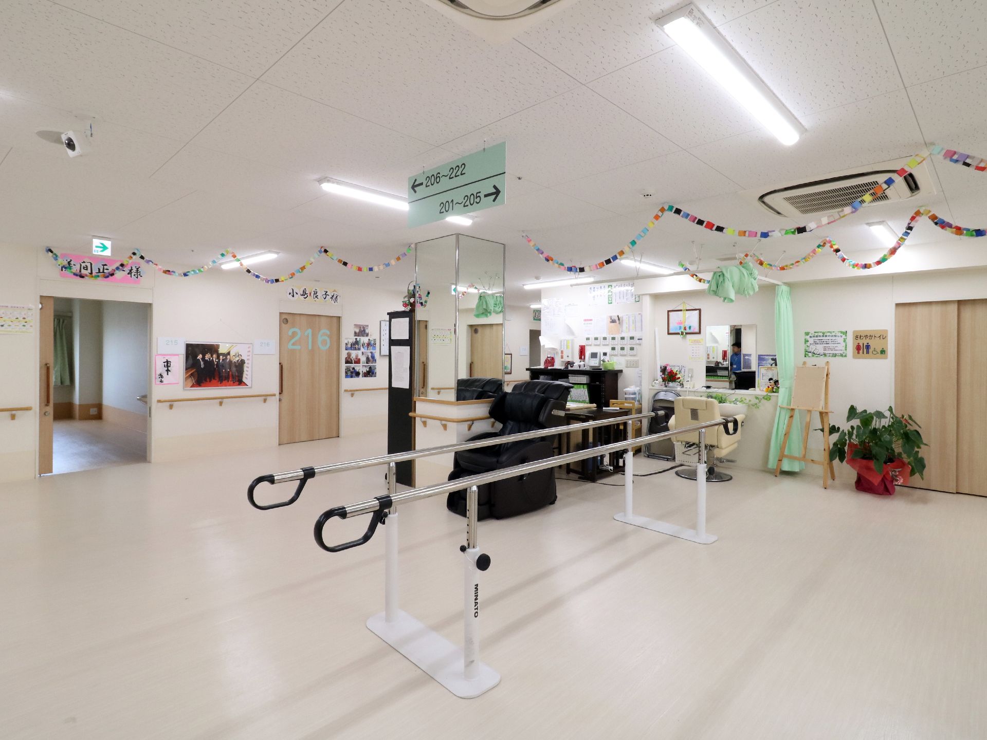 白いフローリングの部屋には歩行のリハビリのための器具が設置されている。天井には空調とライトがともり装飾がされている。