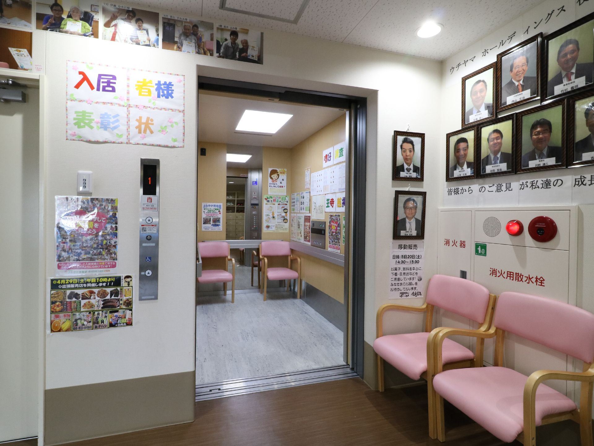 エレベーターの中の壁には手すりと鏡がありさまざまな張り紙がしてある。椅子も置いてあり、周辺のかべにもいろいろな物が飾られている。
