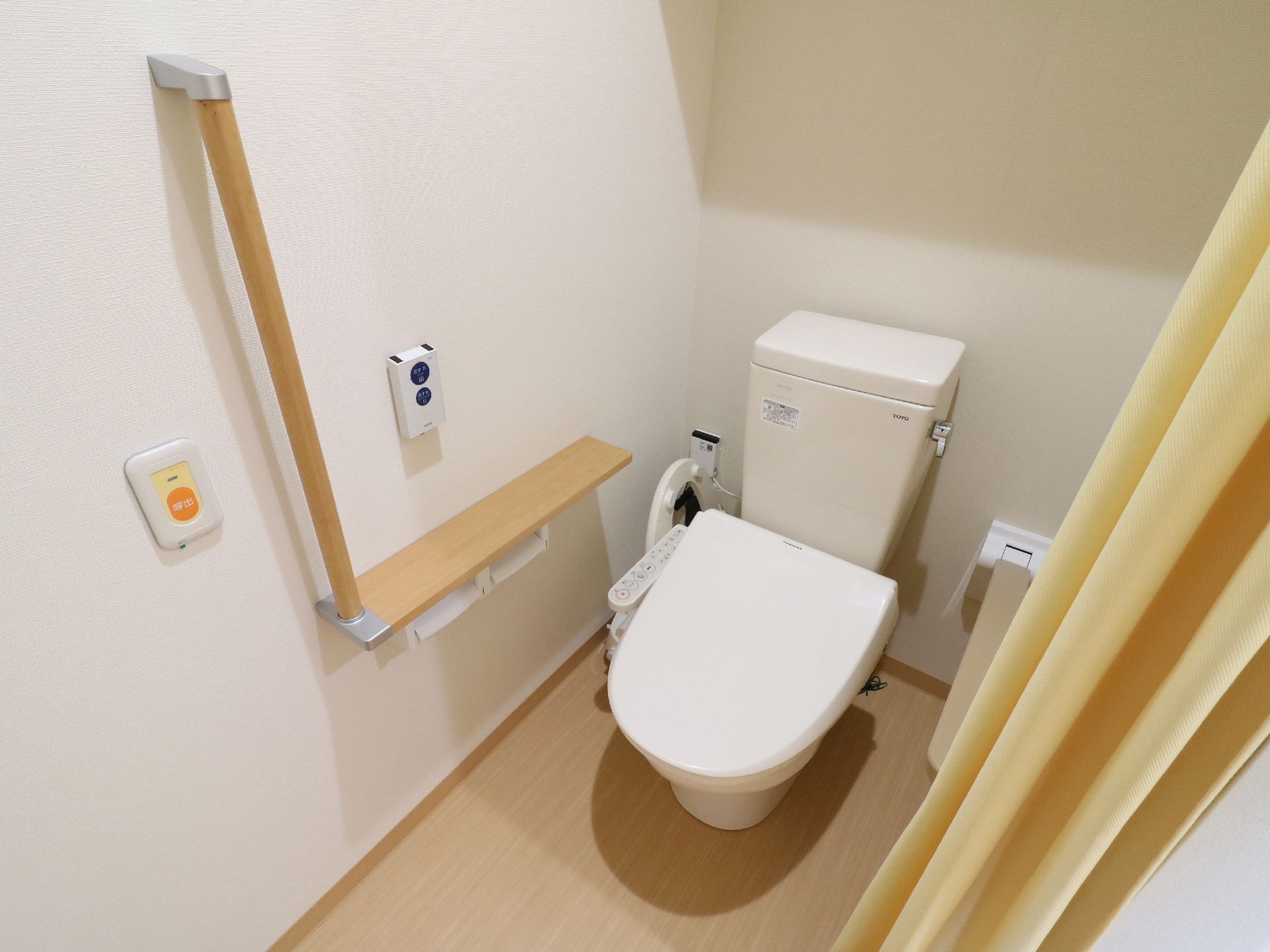 明るいといれである。要所には手摺が設けられている。また、介護職員を呼び出したいときのためのボタンも設置されている。