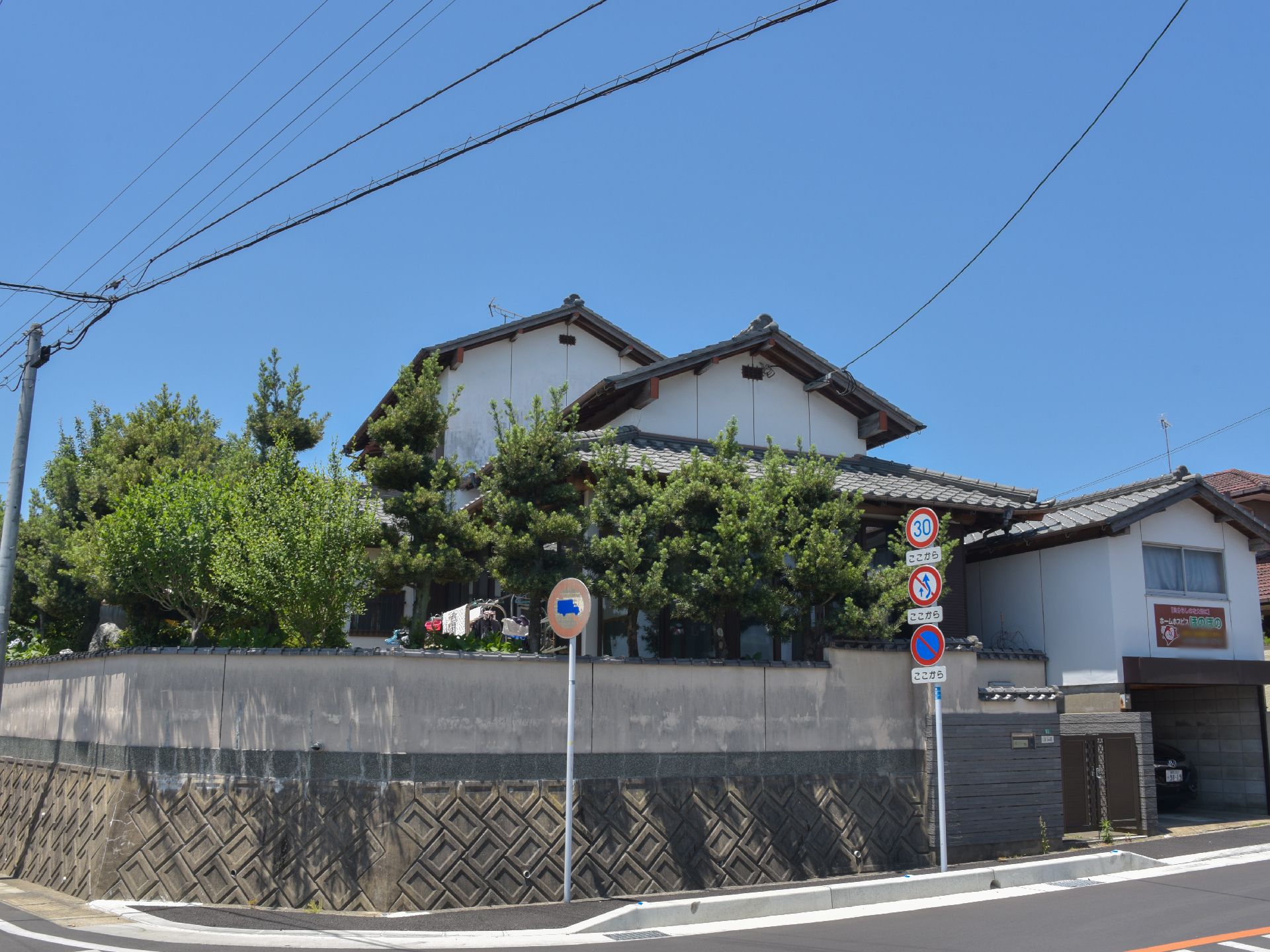 大きな二階建ての建物である。道路に面しているが、高い塀があり、道路から高いところに建っている。庭には大きな木がたくさんある。