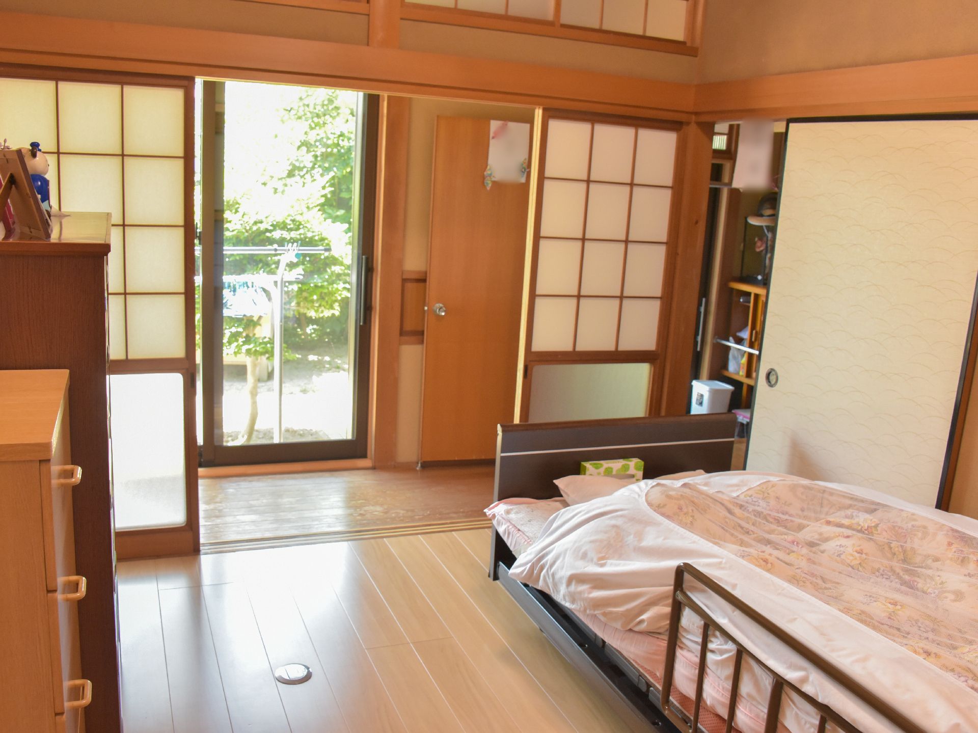 障子で仕切られたフローリングの部屋に置かれたベッドとタンス