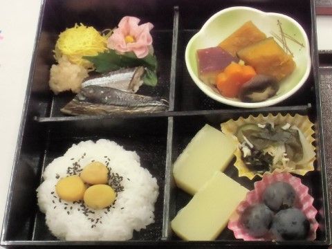 黒い弁当箱に、行楽弁当のように色とりどりのメニューが並んだ食事