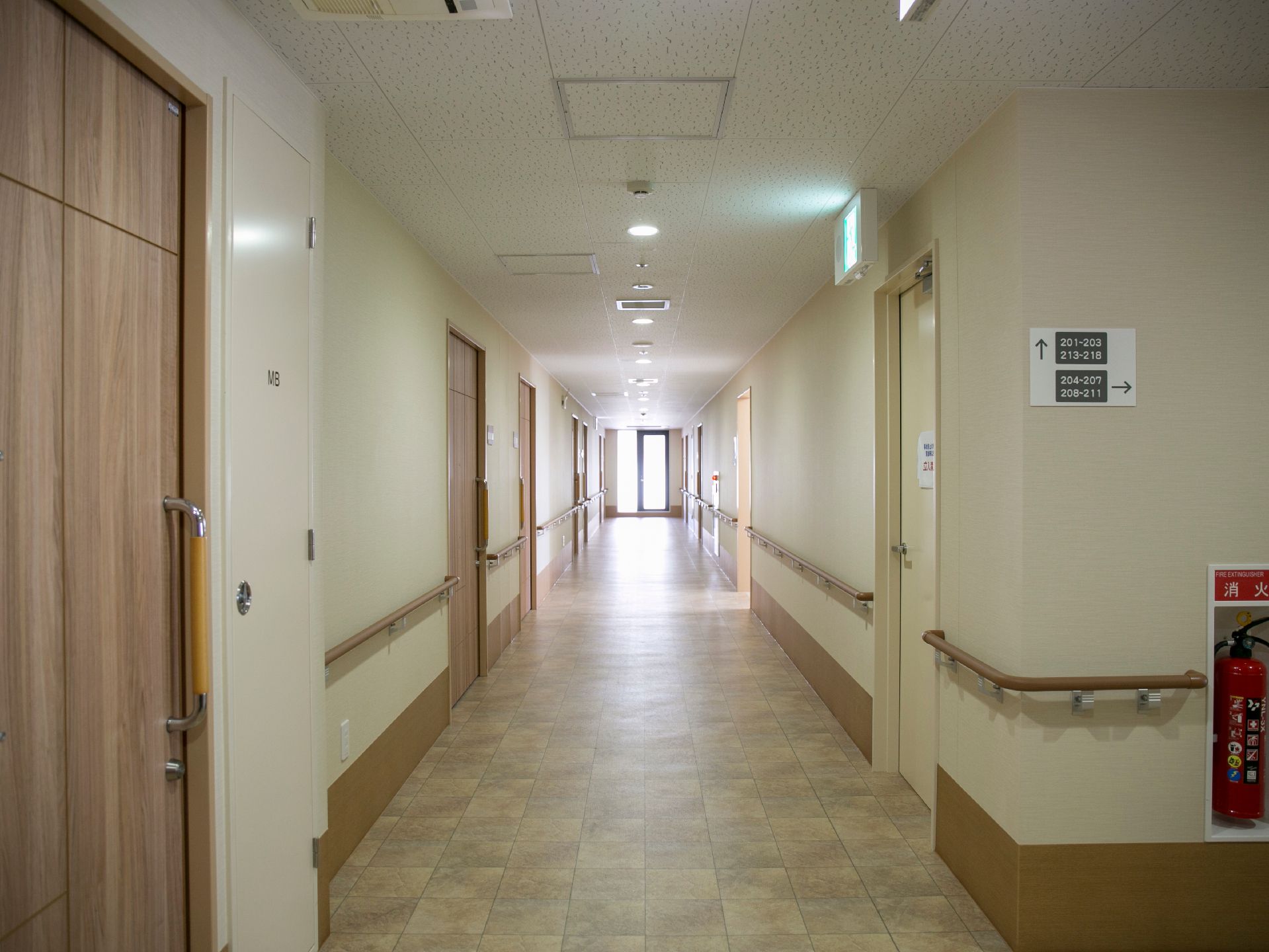 廊下は広く安全を配慮した手すりが両側に設けられている。消火栓が備えられ、非常口案内や壁に部屋番号の案内がある。