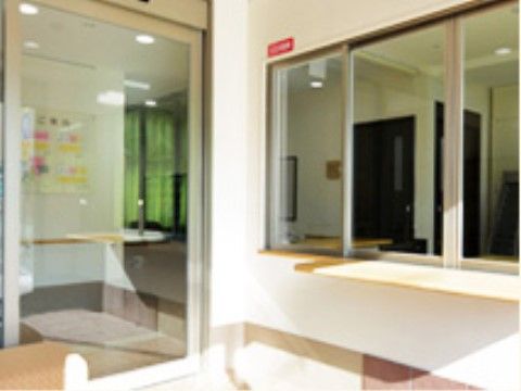 窓口があるエントランスは、入口からの自然光がたっぷりと注がれる明るい雰囲気である。幅の広い自動ドアを通じて施設内を出入りすることができる。