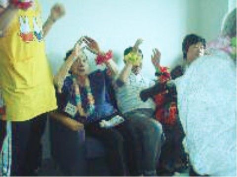 花飾りをつけてダンスを楽しむ高齢者