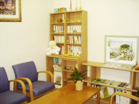 くまのぬいぐるみがのった本棚とテーブルセットが設置された図書コーナー