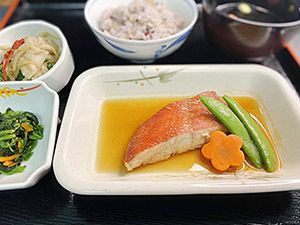 いんげんと花型のにんじんを添えた魚の煮つけと、ご飯と吸い物のセット