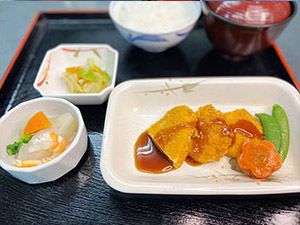 さやえんどうとにんじんを添えた一口大の揚げ物と、ご飯と汁物のセット