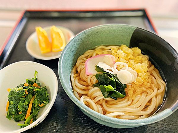 菜の花の和え物と、わかめと天かすがとかまぼこをのせたうどんと、カットオレンジ
