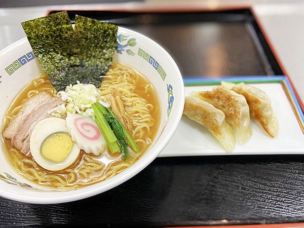 チャーシューと、卵、なると巻き、海苔がのったラーメンと、餃子3個