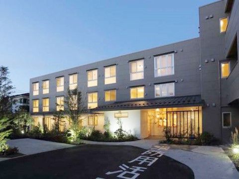 夜間に明かりが灯る3階建ての建物