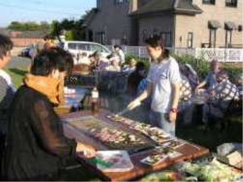 庭でバーベキューが開催され、ガーデンチェアでゆっくり食事を楽しむ入居者様