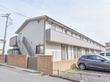 施設は2階建てになっている。ベランダが見え、2階に繋がる階段も端っこにある。隣には車の駐車場がある。