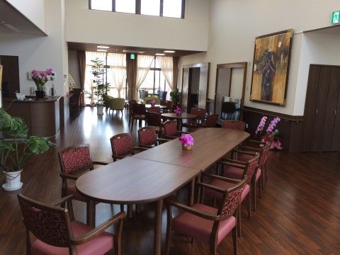 花が飾られたテーブルと赤い椅子が配置されたダイニング
