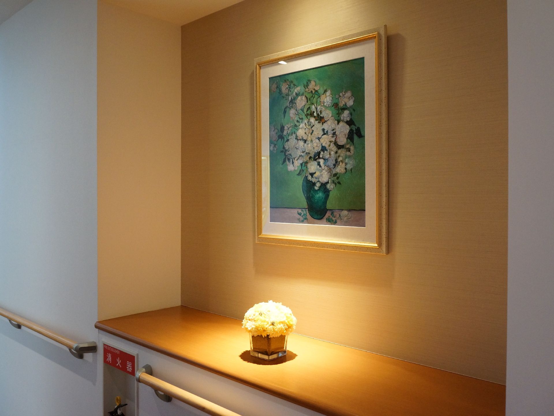 廊下の途中に花の絵と花を飾っています。間接照明により、とても温かみのある雰囲気になるよう工夫しています。