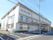 建物の前面から裏側にかけて、屋根が斜めに付いている。前面には駐車場を配置して、車止めのブロックもある。