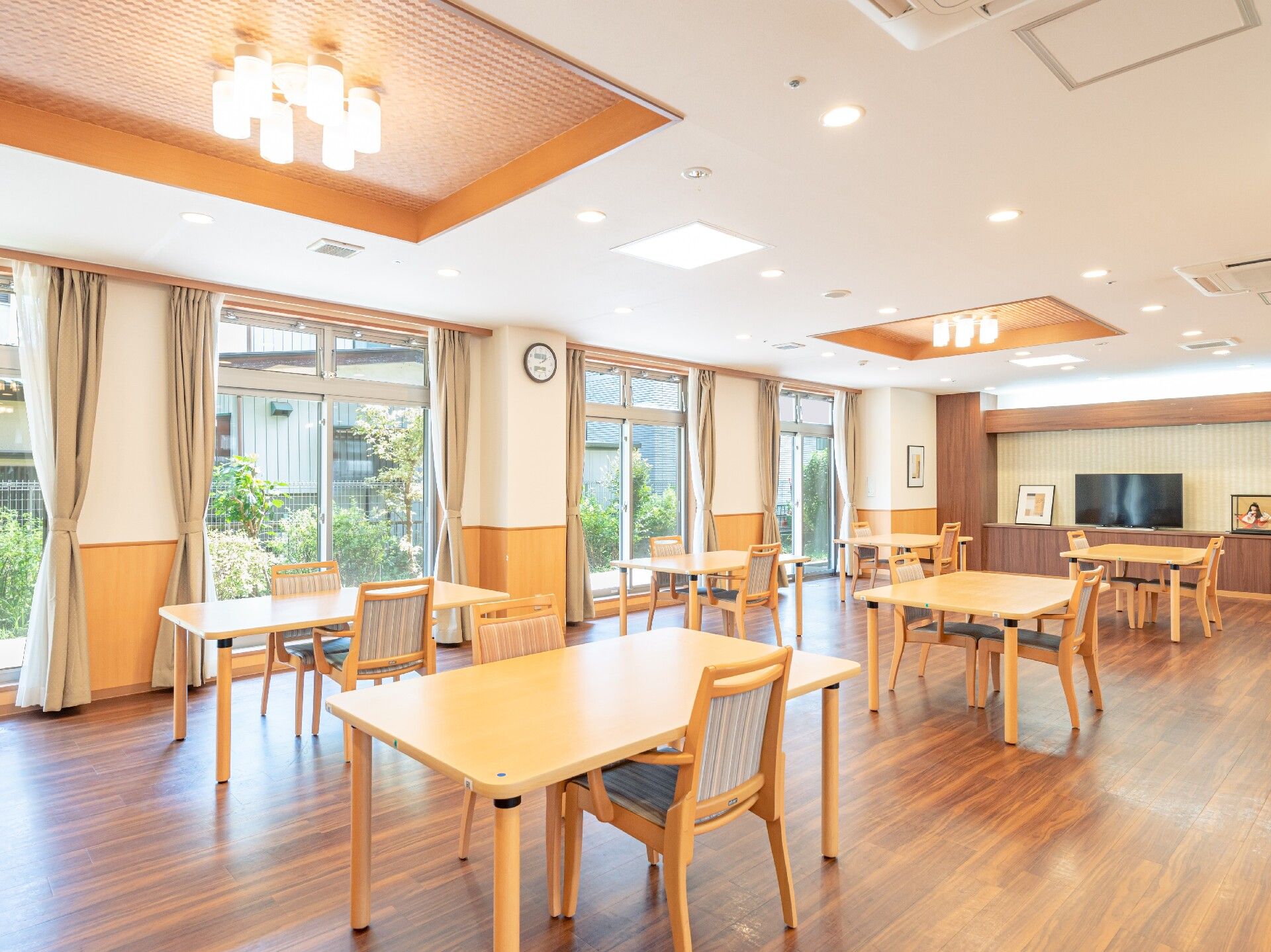 食堂には、流し台やポットが２つ置かれた食器棚が置かれている。食器棚は転倒防止の突っ張り棒が取り付けられている。