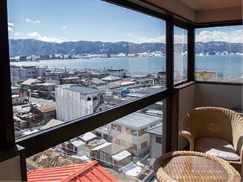 ホームから見える風景。手前には住宅街が広がり、遠くに湖が見える。施設内にはテーブルと椅子が置かれている。