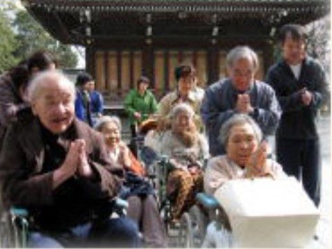 スタッフが入居者様を介助して外出し、神社仏閣で参拝している様子