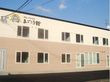 ２階建てのクリーム色と茶色の外壁の当施設。当施設名が分かりやすい位置に書いてある。駐車スペースもあるため、遠方の方でも利用しやすい。