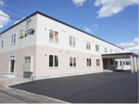 白い２階建ての建物で、多くの車が駐車でき、エントランスは屋根付きで車ごと入れ、天候に左右されずスムーズに乗り降りできる。