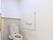 明るく清潔なトイレには、L字型の手すり、温水便座、棚が設置されている。介護が必要な際にも対応できる広さがある。