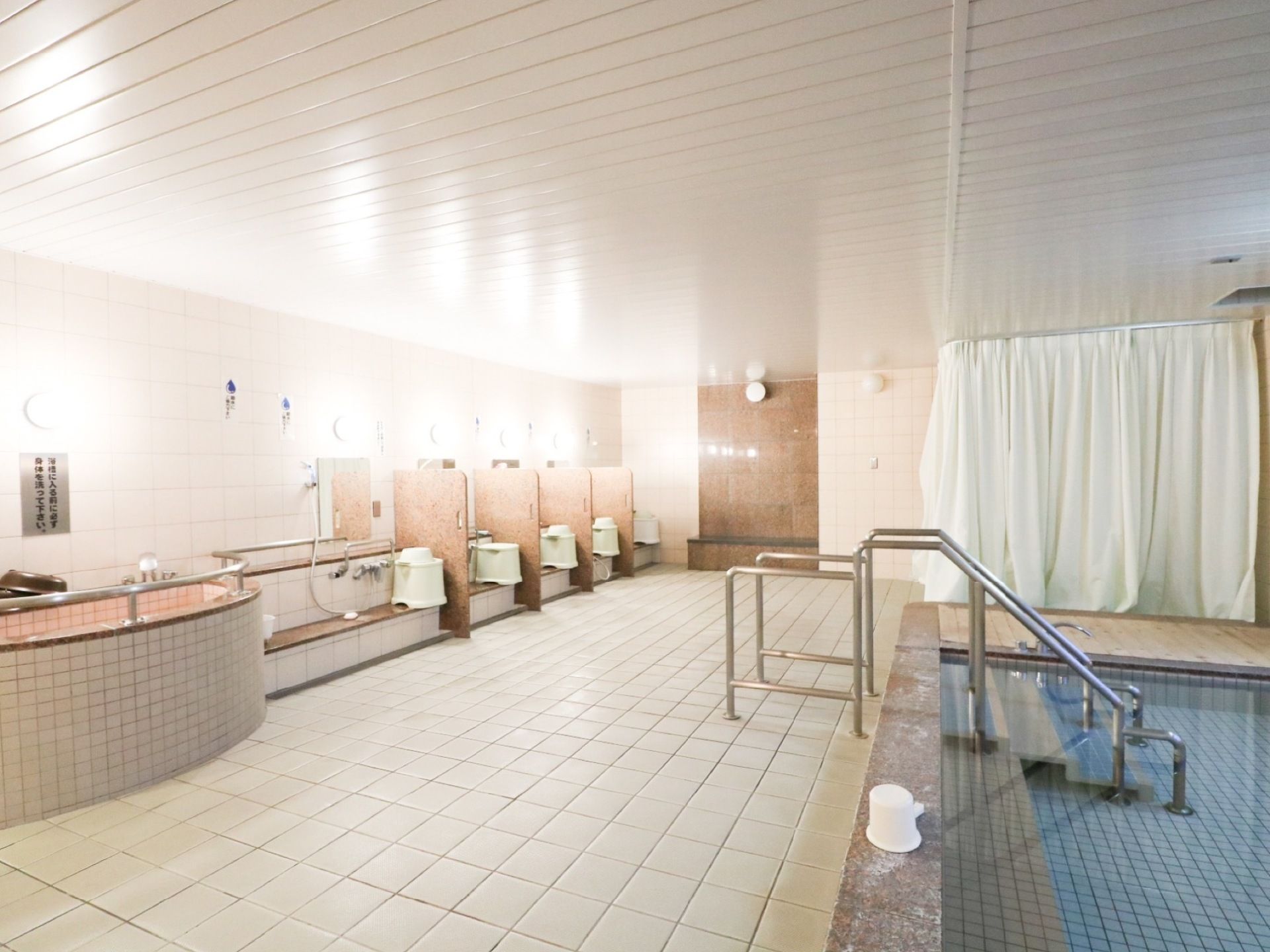 入居者様共用の浴室は、複数の洗い場があるほか、プールのような大きな浴槽がある。浴槽の出入り口には手すりがかかっている。