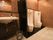 トイレは、赤色と黒色のまだら模様の壁と白色、黒色の床というデザインの室内である。洗面台の横に小便器が２据設置されている。