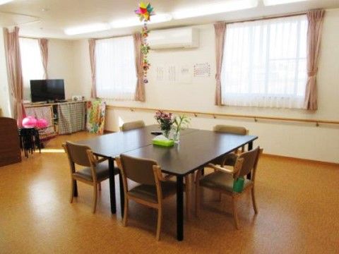 テレビや4人掛けのテーブルが設置された居間