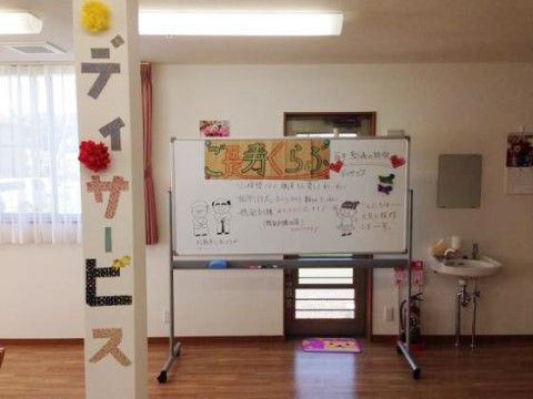 ホワイトボードが設置されたデイサービスの部屋