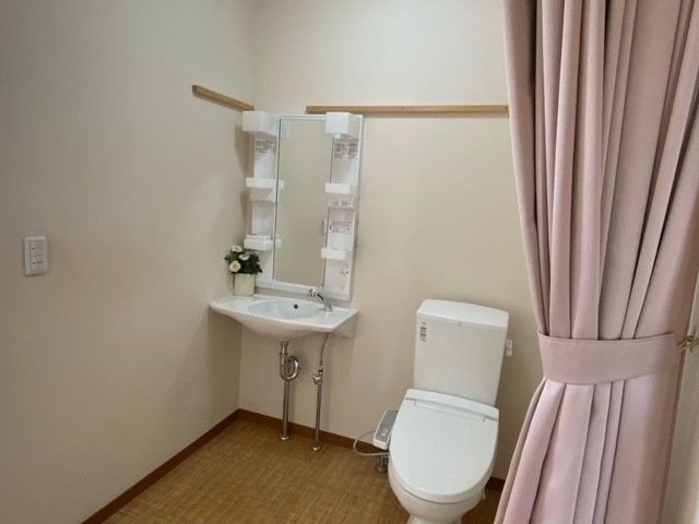 Ｌ字型手すりや可動式手すりが設置されたトイレ