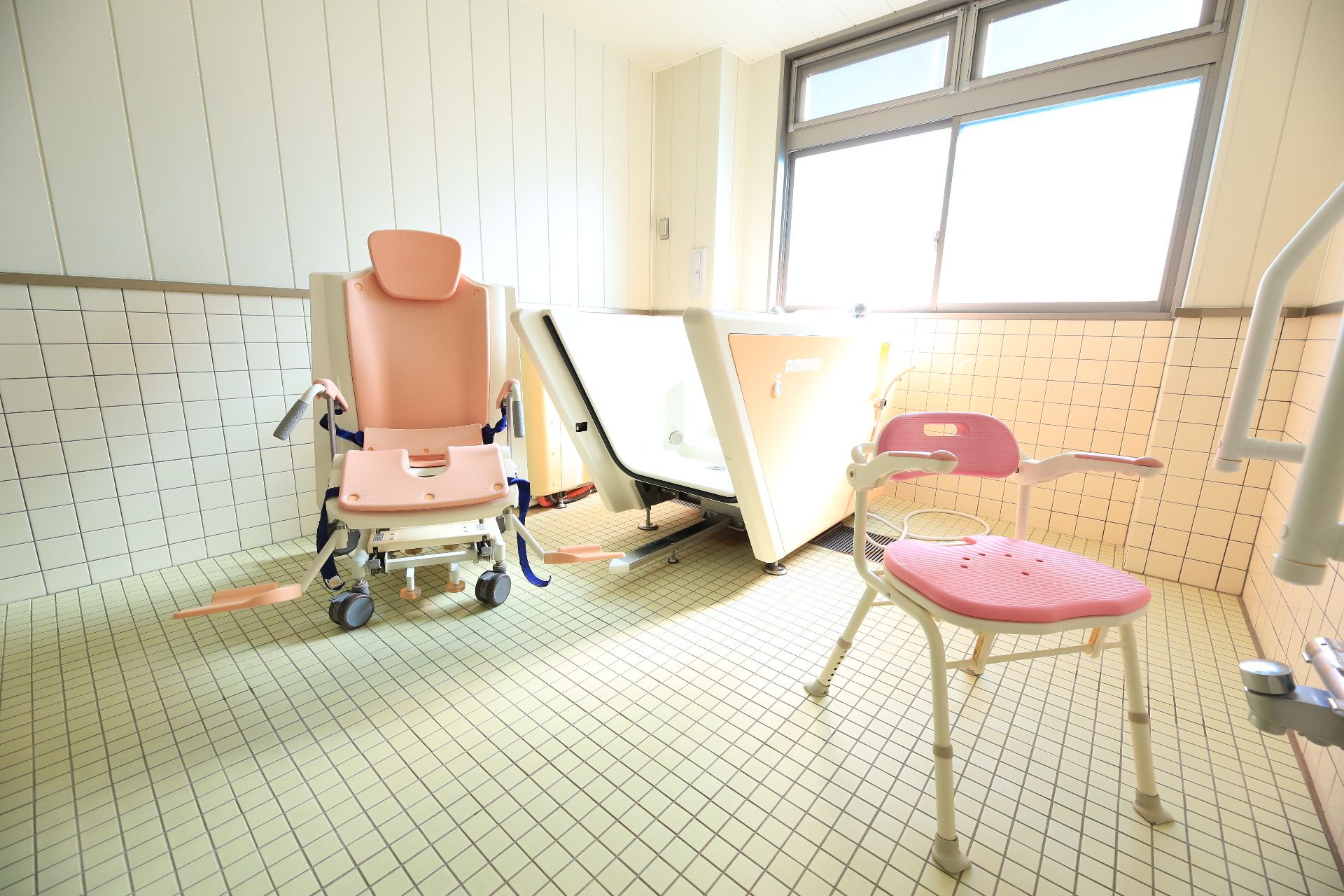 浴室用車椅子や機械浴槽が設置された、広く清潔感のある浴室