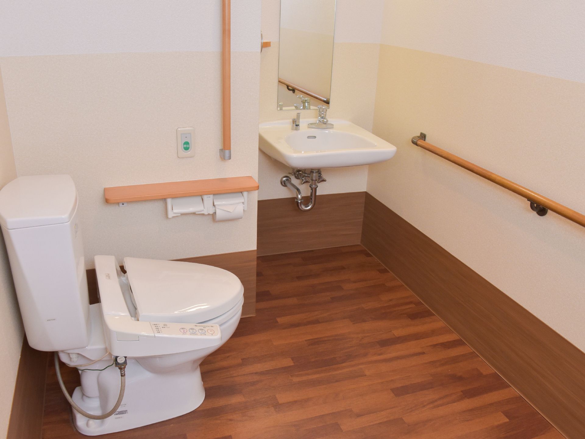 トイレと洗面所が1つの空間になっている。トイレットペーパーフォルダーの上には呼び出しボタンが設置されている。