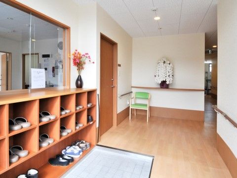 エントランスの壁には靴箱が取り付けられており、上にガラス張りの窓が設置されている。壁際には椅子が置かれている。