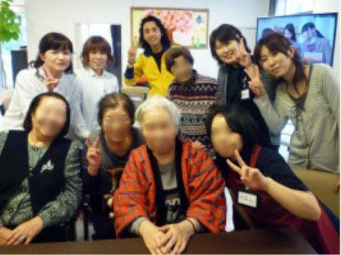 カメラに向かって笑顔でポーズをとる、入居者様とスタッフたち